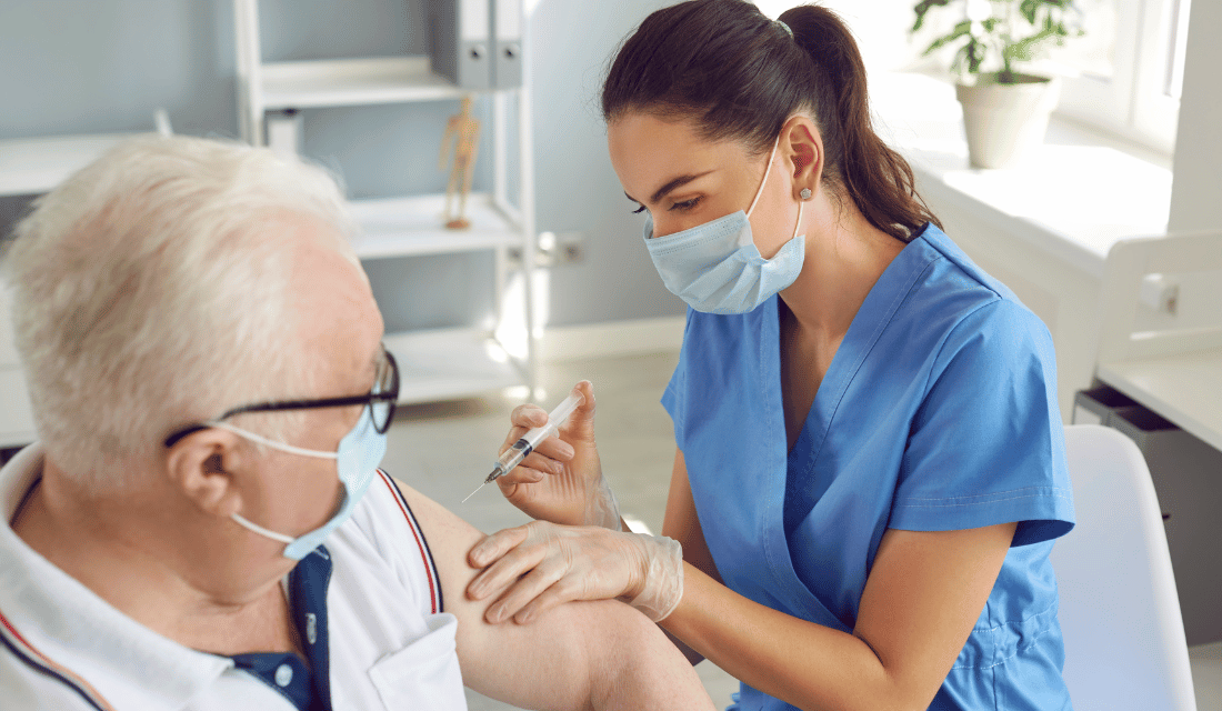 Un homme se fait vacciner par une infirmière